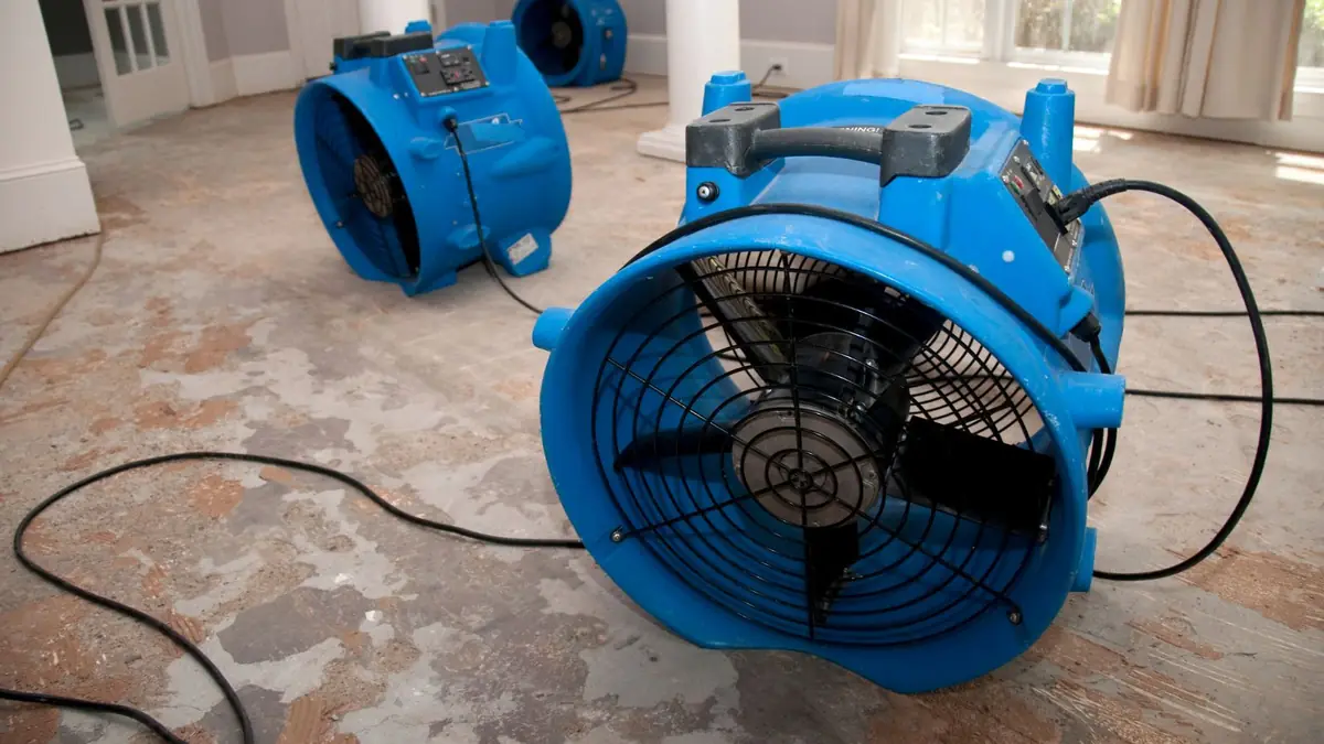 Large blue air mover drying a floor after flooding
